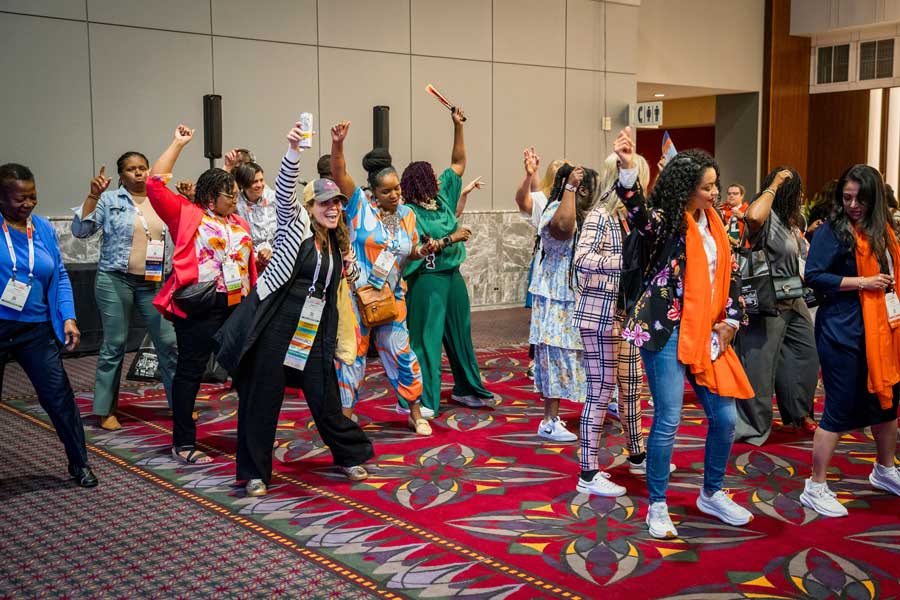 a group of people dancing at a conference 