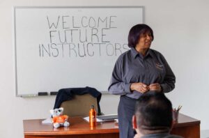 an instructor stands at the front of a classroom