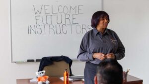 an instructor stands at the front of a classroom
