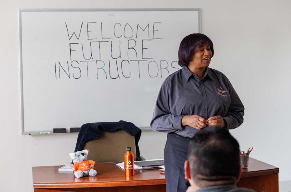 an instructor stands at the front of a classroom
