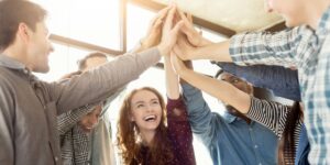 people celebrating with their hands in the middle of a circle