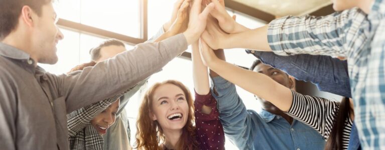 people celebrating with their hands in the middle of a circle