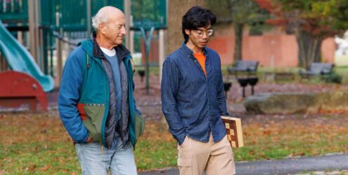 an older man and a younger man walk together