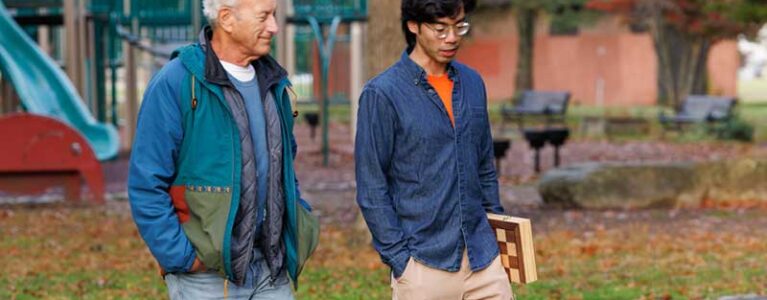 an older man and a younger man walk together