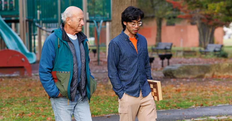 an older man and a younger man walk together